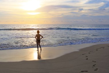 Günbatımı kumsalda bikini, sahne güzel kadın arkadan görünüş.