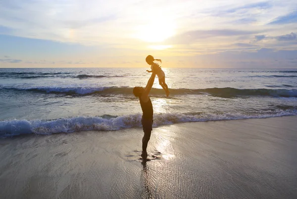 Σιλουέτα Του Πατέρα Ρίχνουν Μικρό Παιδί Κορίτσι Στην Παραλία Ηλιοβασίλεμα — Φωτογραφία Αρχείου