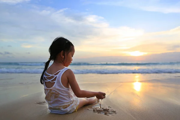 Visão Traseira Menina Asiática Sentada Jogando Areia Praia Pôr Sol — Fotografia de Stock