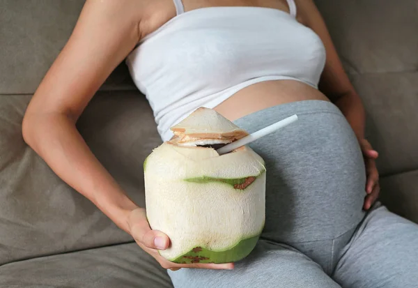 Pregnant Woman Sitting Sofa Holding Coconut Her Tummy — Stock Photo, Image