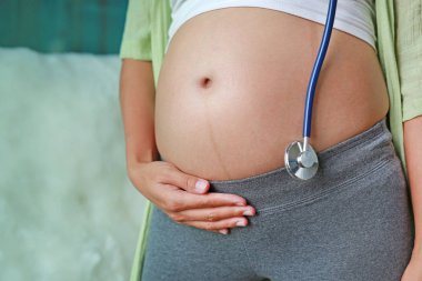 Ayakta ve karnı stetoskop asma dokunmadan hamile kadınlar.