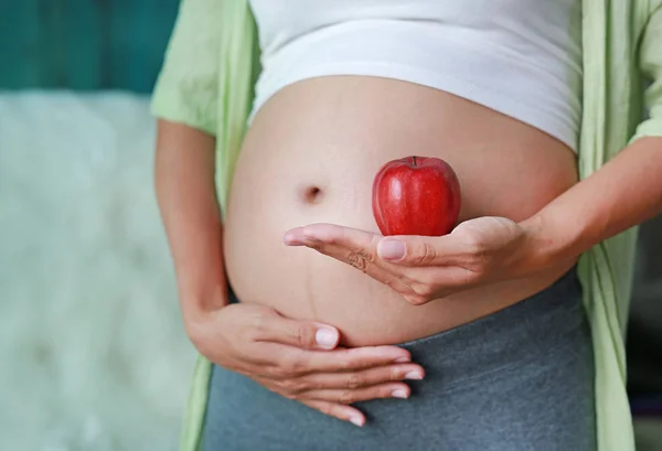 Kobieta Ciąży Posiadający Czerwone Jabłko Brzuszku — Zdjęcie stockowe