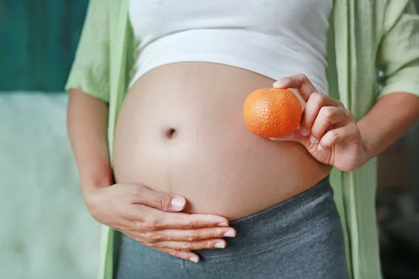 Gravid Kvinna Som Håller Orange Frukt Hennes Mage — Stockfoto