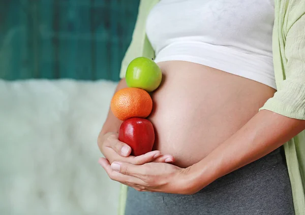 Kobieta Ciąży Posiadający Apple Zielony Czerwony Pomarańczowy Owoc Jej Brzuch — Zdjęcie stockowe