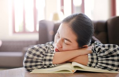 Genç Asyalı kadın dinlenmek ve kütüphanede uyku.