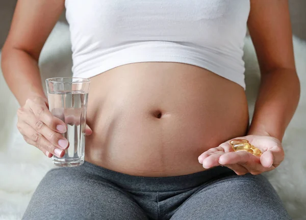 Gravid Kvinna Hand Med Glas Med Vatten Och Fisk Olja — Stockfoto