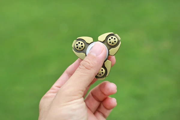 Hand Hält Metall Fidget Spinner Spielzeug Grünen Gras Hintergrund — Stockfoto