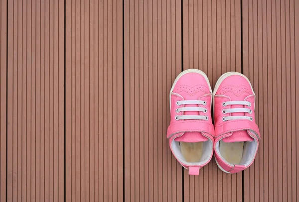 双粉红色婴儿皮鞋在木板背景 — 图库照片