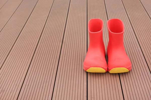 Παιδί Κόκκινο Λαστιχένιες Μπότες Φόντο Ξύλινη Σανίδα — Φωτογραφία Αρχείου
