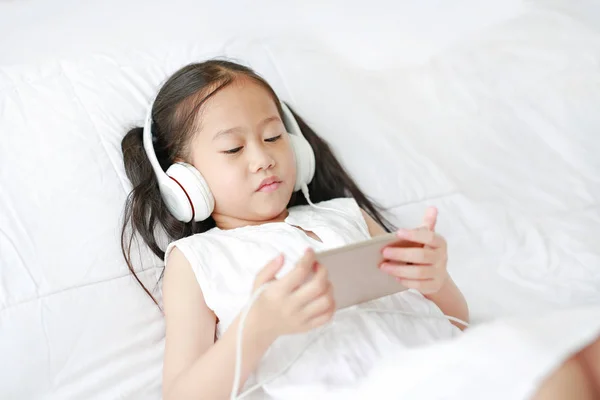Portrét Malé Asijské Dívky Používající Sluchátky Poslech Hudby Smartphone Zatímco — Stock fotografie