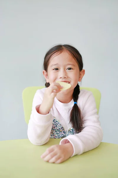 Porträtt Lycklig Liten Asiatisk Barnflicka Äter Krispiga Chips Vit Bakgrund — Stockfoto