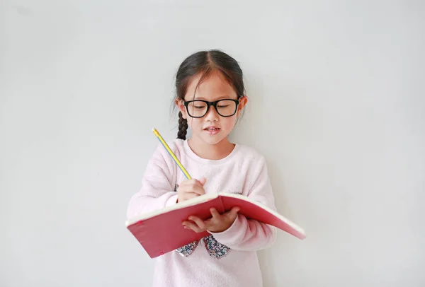 Intend Malý Asijské Dívka Nošení Brýle Držení Píše Notebooku Tužkou — Stock fotografie