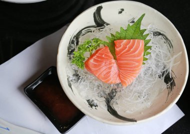 Japon usulü taze buzlu somon balığı ya da somon balığı dilimi ve siyah masada taze wasabi. Üst görünüm.