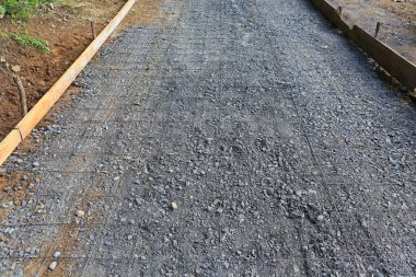 Beton yol oluşturmak için taş karışımına yerleştirilmiş çelik tel örgüler.