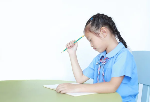 Στρεσαρισμένο Κοριτσάκι Σχολική Στολή Κάθεται Στο Γραφείο Απομονωμένο Λευκό Φόντο — Φωτογραφία Αρχείου