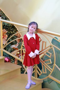 Kırmızı elbiseli güzel Asyalı kız kış mevsiminde poz veriyor ve yılbaşı arkaplanına karşı yeni yıl festivaliniz kutlu olsun..