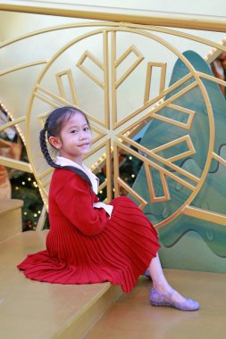 Kırmızı elbiseli güzel Asyalı kız kış mevsiminde poz veriyor ve yılbaşı arkaplanına karşı yeni yıl festivaliniz kutlu olsun..