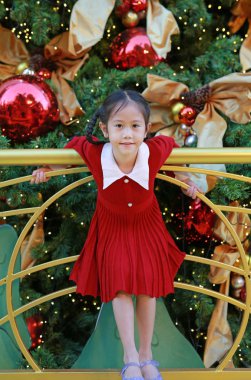 Kırmızı elbiseli güzel Asyalı kız kış mevsiminde poz veriyor ve yılbaşı arkaplanına karşı yeni yıl festivaliniz kutlu olsun..