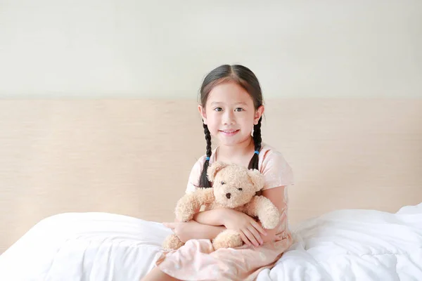 Sorrindo Asiático Menina Pequena Abraçar Ursinho Pelúcia Olhando Câmera Enquanto — Fotografia de Stock
