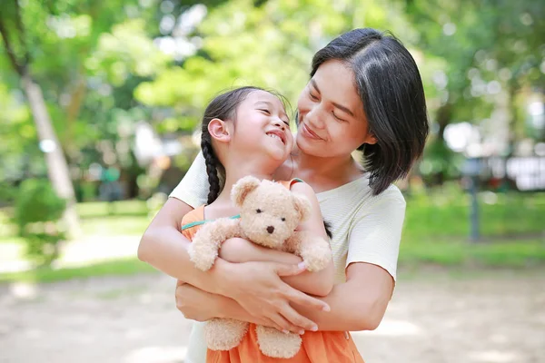 Portret Szczęśliwej Azjatyckiej Matki Przytulać Córkę Przytulania Misia Lalka Ogrodzie — Zdjęcie stockowe