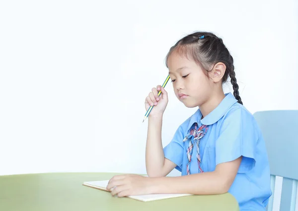 Allvarlig Liten Flicka Skoluniform Sitter Vid Skrivbordet Isolerad Över Vit — Stockfoto