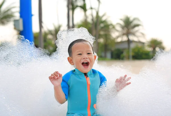 穿着游泳衣的亚洲小男孩在户外的泡沫派对上玩得很开心 很开心 图库照片
