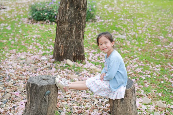 Gadis Kecil Bahagia Duduk Kayu Kayu Melawan Jatuh Bunga Merah — Stok Foto