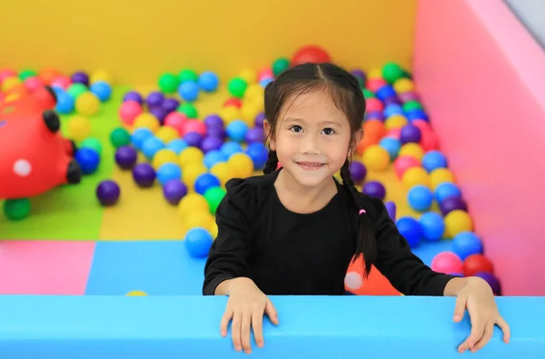 Mosolygó Ázsiai Lány Játszik Egy Gyerek Labdarúgó Gödörben Egy Játszótéren — Stock Fotó