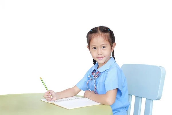 Niña Asiática Sonriente Uniforme Escolar Escribiendo Cuaderno Escritorio Aislado Sobre — Foto de Stock