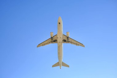 Mavi arka planda uçan uçak. Görünümün altında.