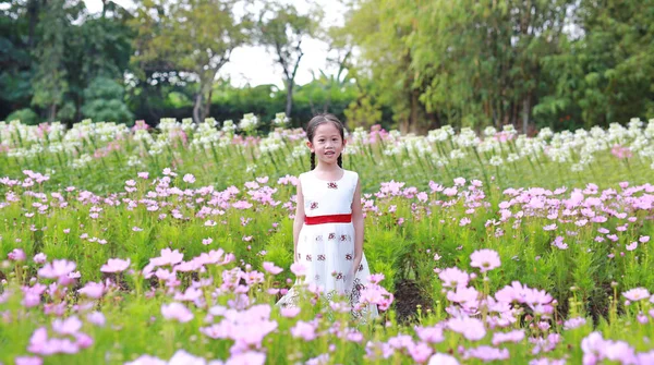 Bahçesinde Çiçekler Olan Beyaz Elbiseli Asyalı Küçük Bir Kızın Portresi — Stok fotoğraf