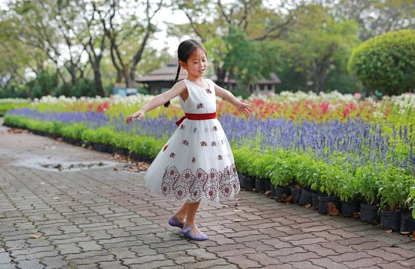 Szczęśliwy Azjatycki Dziewczynka Taniec Zabawy Ogrodzie Świeże Kwiaty Dzieciak Bawić — Zdjęcie stockowe