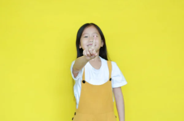 黄色の背景に1番の指を示す小さなアジアの子供の女の子 子供は教育の概念のための指で数える 彼の手に焦点を当て — ストック写真