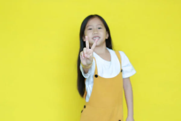 Μικρό Ασιατικό Κοριτσάκι Που Δείχνει Δάχτυλο Νούμερο Δύο Απομονωμένο Κίτρινο — Φωτογραφία Αρχείου