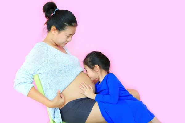 Menina Asiática Beijando Bebê Barriga Mãe Grávida Isolada Fundo Rosa — Fotografia de Stock