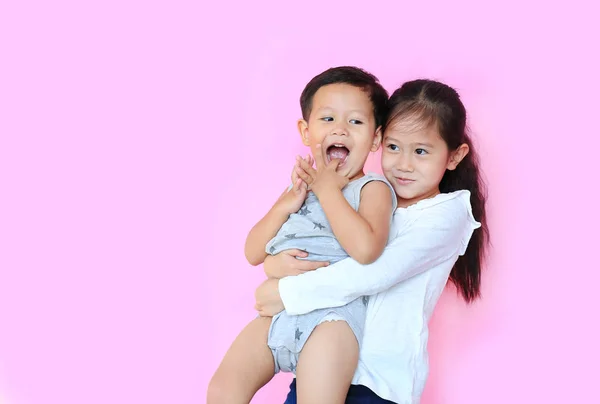 Cheerful Asian Sister Hugging Her Little Brother Isolated Pink Background — Stock Photo, Image