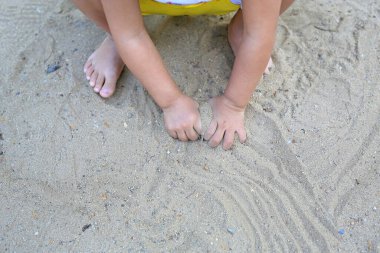 Bahçede çamurla oynayan bebeğin ellerini kapat.