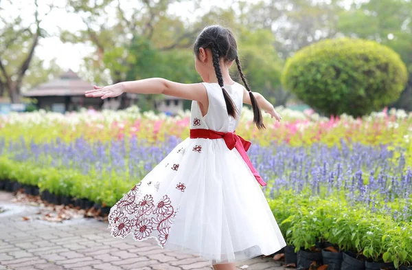 Menina Vestido Branco Andando Com Flores Redor Jardim Vista Traseira — Fotografia de Stock