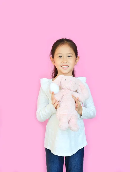Lächelnde Asiatische Kindermädchen Mit Rosa Flauschigen Hasenpuppe Isoliert Auf Rosa — Stockfoto