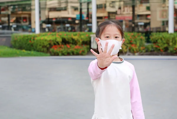 Covid 19和空气污染停止概念 在公众地方 亚洲小女孩戴着口罩以保护头皮海象和Pm2 5灰尘 并在户外展示手掌 专注于孩子的手 — 图库照片