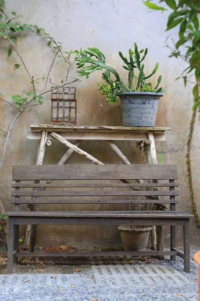 古いセメントの壁の背景に庭の古い木製の椅子 — ストック写真
