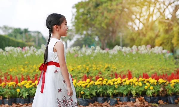 花の庭で笑顔の小さな女の子の肖像画 — ストック写真
