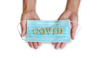 Beyaz arka plan üzerinde izole tutulan insanlarda COVID yazılı tıbbi kalkanlı bandaj maskesi..