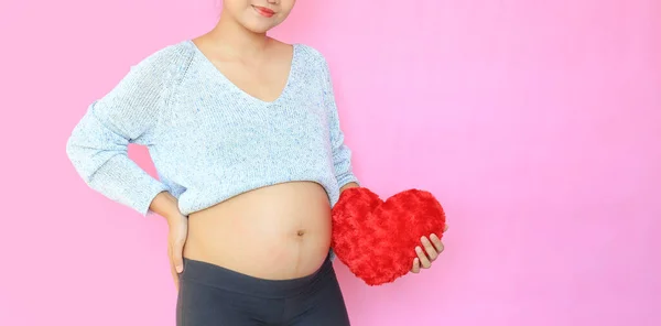 Close Těhotná Žena Drží Červené Srdce Polštář Břiše Izolované Růžovém — Stock fotografie