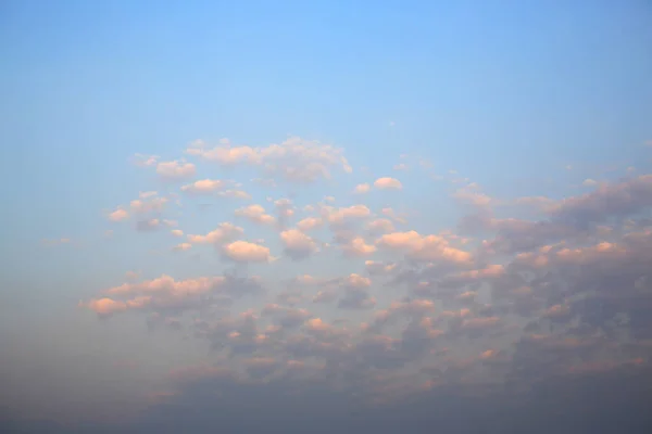 日落时蓝天背景上的粉色蓬松的云彩 — 图库照片