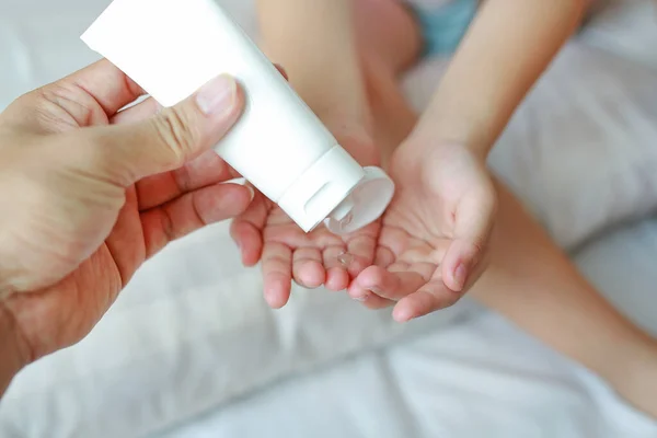 母亲的手使用塑料瓶中的酒精凝胶清洁婴儿的手 以获得卫生和抗病毒的细菌 — 图库照片