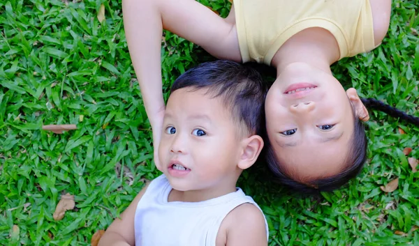 สาวเอเช ความส ขและน องชายท นอนบนพ นหล งหญ ปภาพของเด งและเด กชายเล — ภาพถ่ายสต็อก