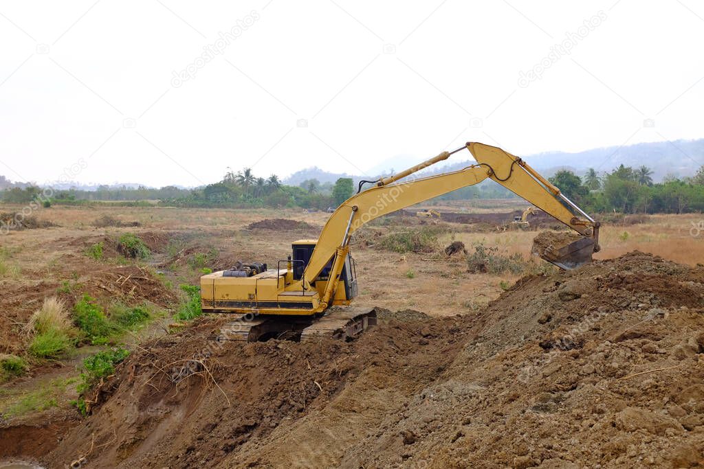 Excavator working digs the ground for water drainage in agriculture system.
