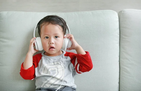 Roztomilý Malý Asijský Chlapeček Sluchátkách Používá Chytrý Telefon Ležící Doma — Stock fotografie