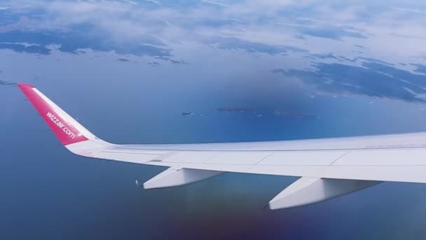 Вид на небо из окна самолета. Окно в море Многие острова близ Норвегии В летний сезон. Wizzair — стоковое видео